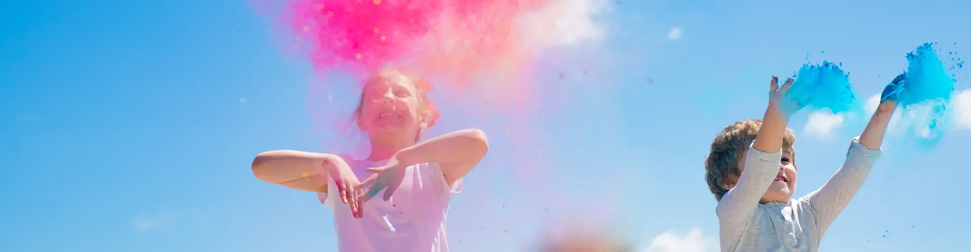 Barn kastar färgpulver i luften