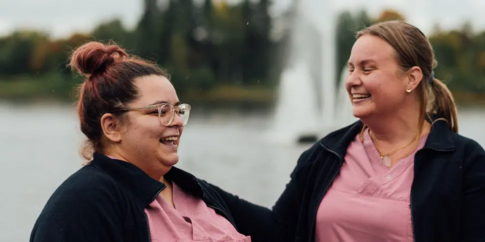 Två kvinnor ler mot varandra